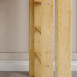 Wooden table leg corner detail against beige wall and carpeted floor.