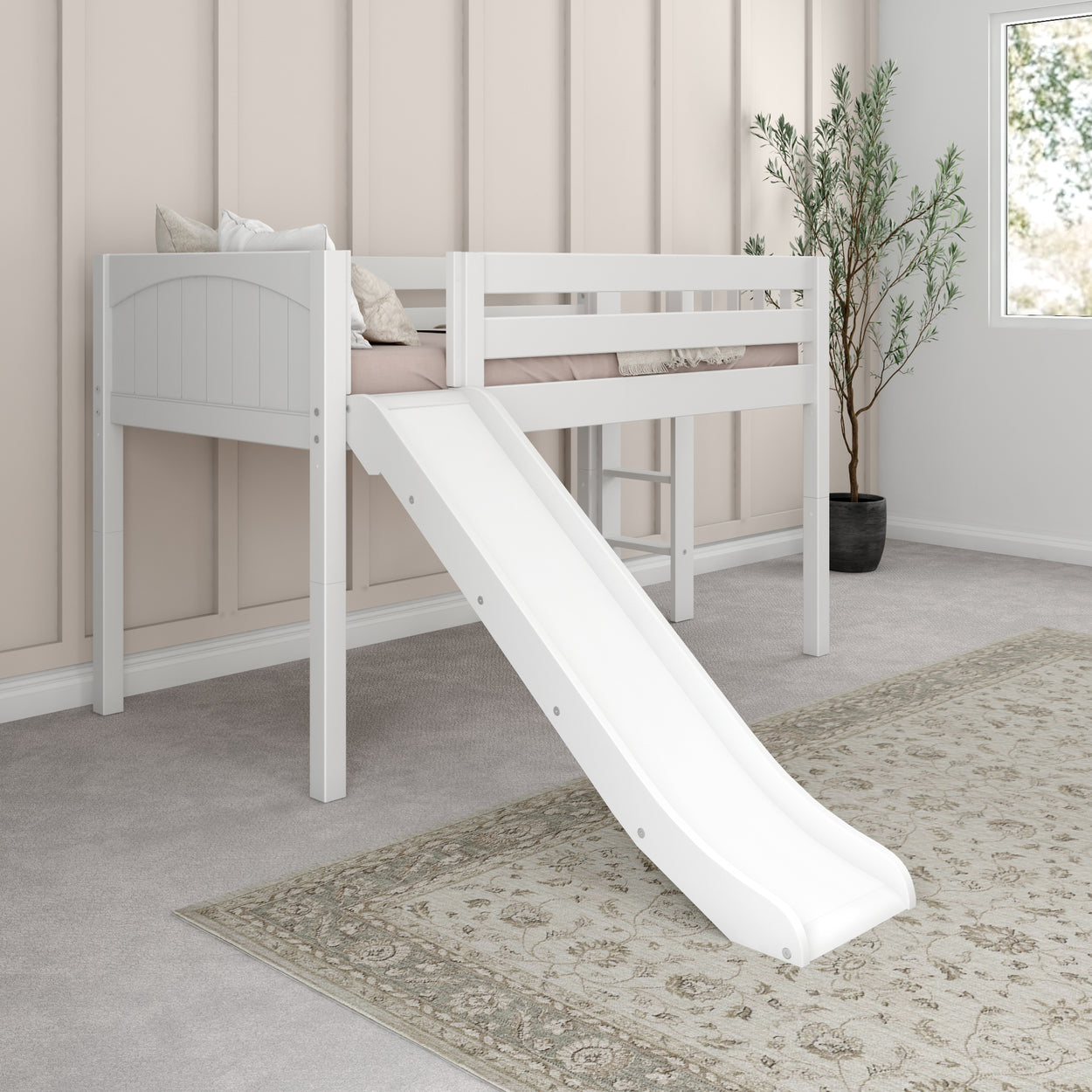 Loft bed with slide in modern children's bedroom, featuring a cozy white frame and plush pillows.
