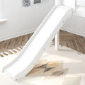White wooden indoor children's slide beside a window in a bright modern nursery with hardwood floors and patterned rug