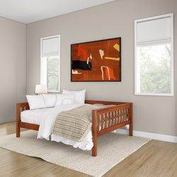 Wooden daybed in modern bedroom with cozy beige blanket and abstract wall art.
