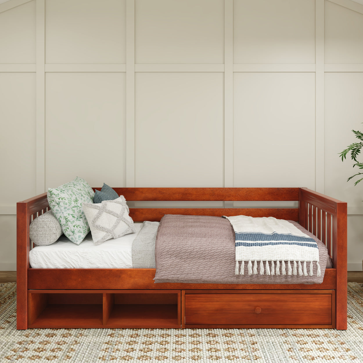 Wooden daybed with storage drawers, decorative pillows, and cozy blankets in a modern bedroom setting.