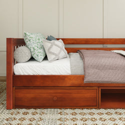 Cozy brown wooden daybed with decorative pillows and a soft knitted blanket, perfect for modern bedroom decor.