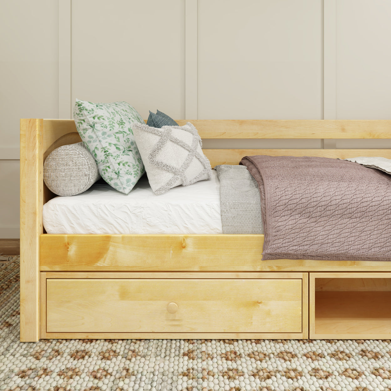 Wooden daybed with decorative pillows and blanket in cozy bedroom setting.