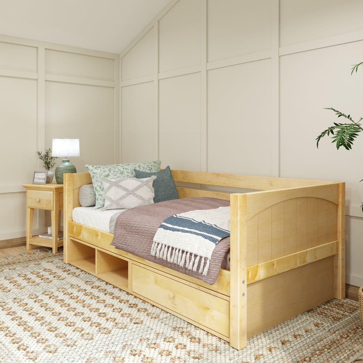 Wooden daybed with storage drawers, decorative pillows, and cozy blanket in a modern bedroom setting.