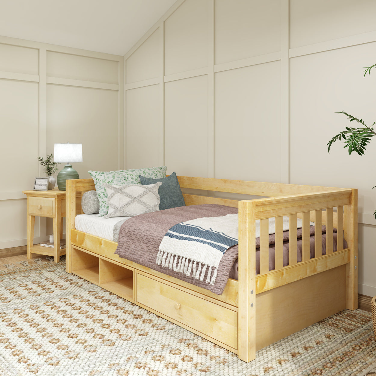Cozy bedroom with a wooden daybed featuring colorful pillows and a woven blanket, next to a wooden nightstand with a lamp and decorative plant.