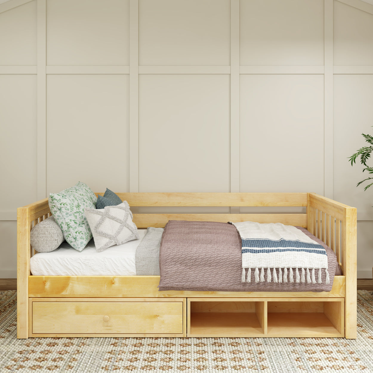 Wooden daybed with storage drawers, decorated with colorful pillows and blankets in a cozy bedroom setting.