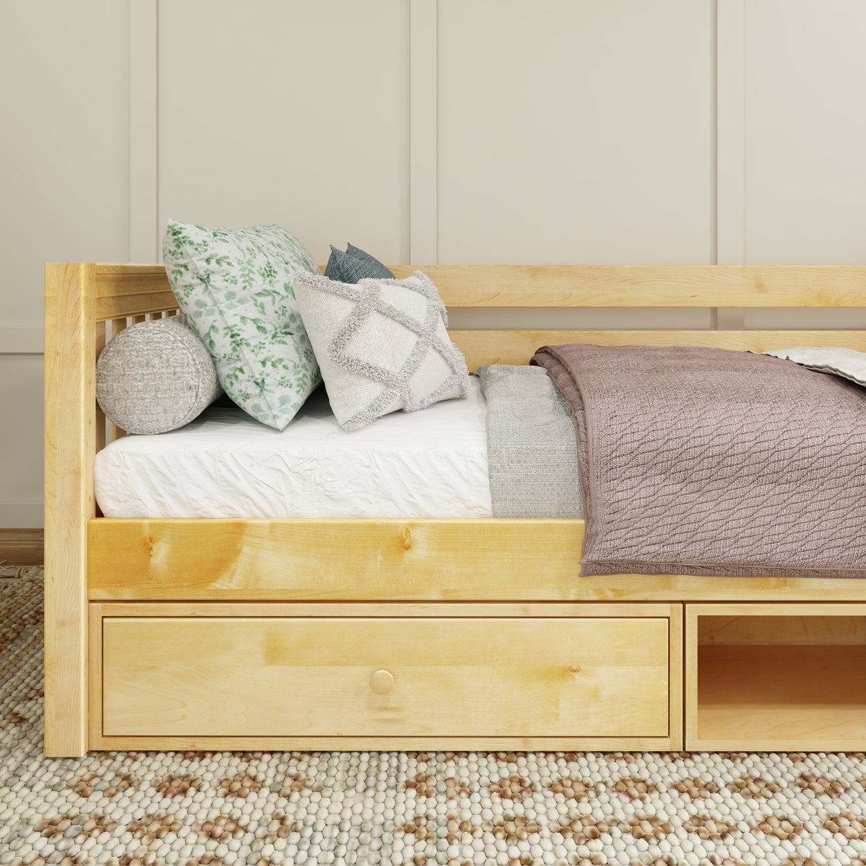 Wooden daybed with decorative pillows and cozy blanket in modern bedroom setting.