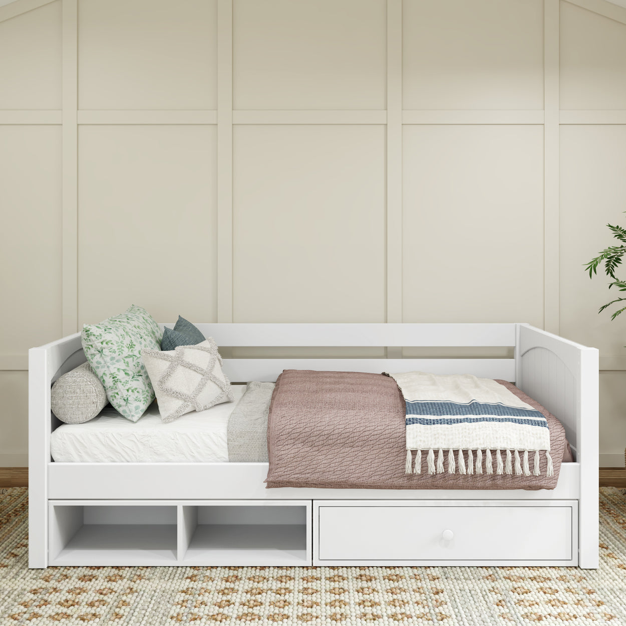 White daybed with storage, featuring decorative pillows and a cozy blanket, in a modern bedroom setting.