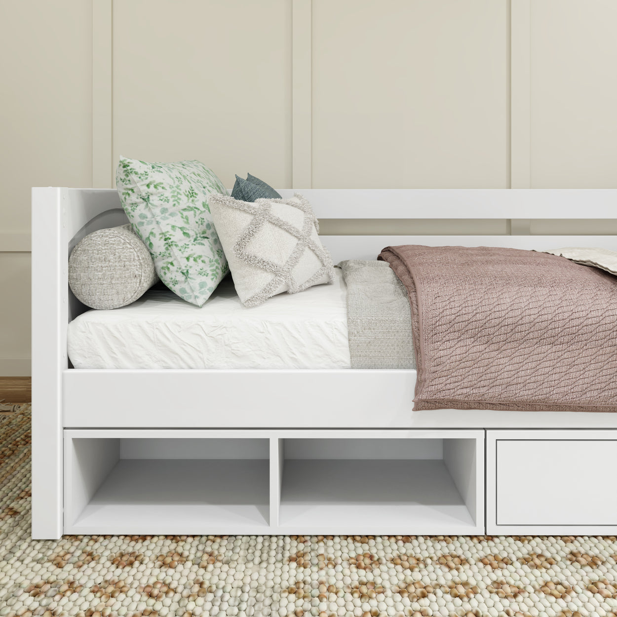 White daybed with cozy pillows and textured blanket in a modern bedroom.