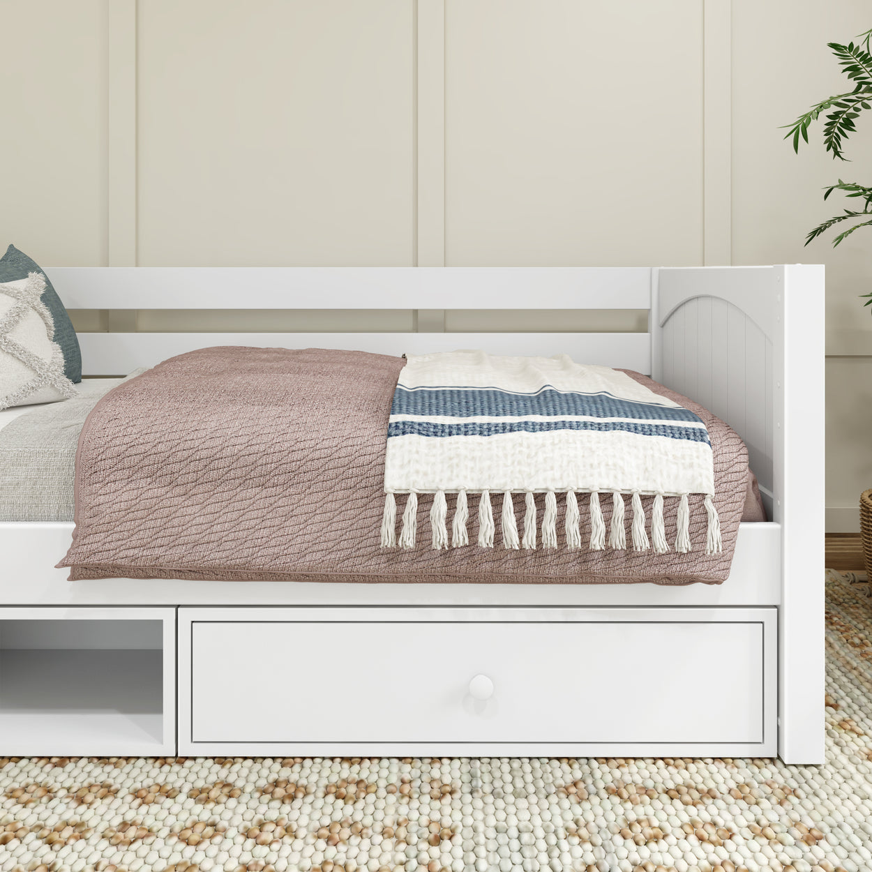 White daybed with blue and white striped blanket and storage drawer in modern bedroom.