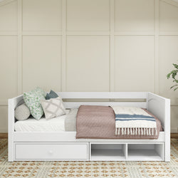 White daybed with storage drawers, decorated with patterned cushions and a throw blanket, in a modern bedroom setting.