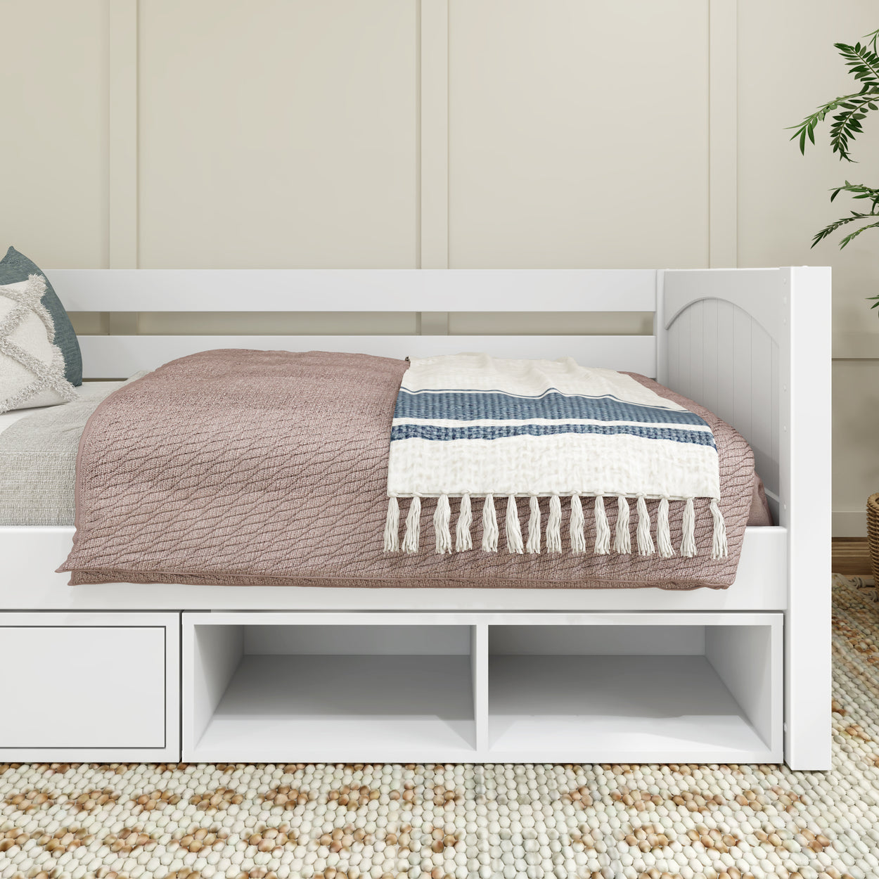 White daybed with cozy blanket and storage underneath, modern minimalist bedroom decor.