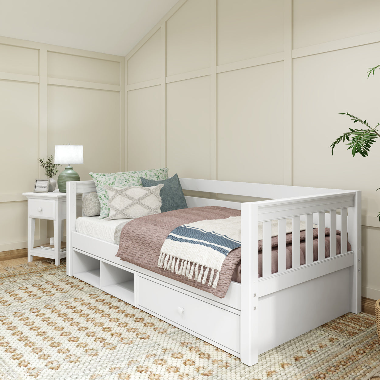 White wooden daybed with storage drawers in a cozy bedroom setting featuring a side table and decorative cushions.