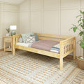 Scandinavian minimalist bedroom with light wood daybed, decorative pillows and knit throw, bedside table with green ceramic lamp, textured cream area rug and potted plant