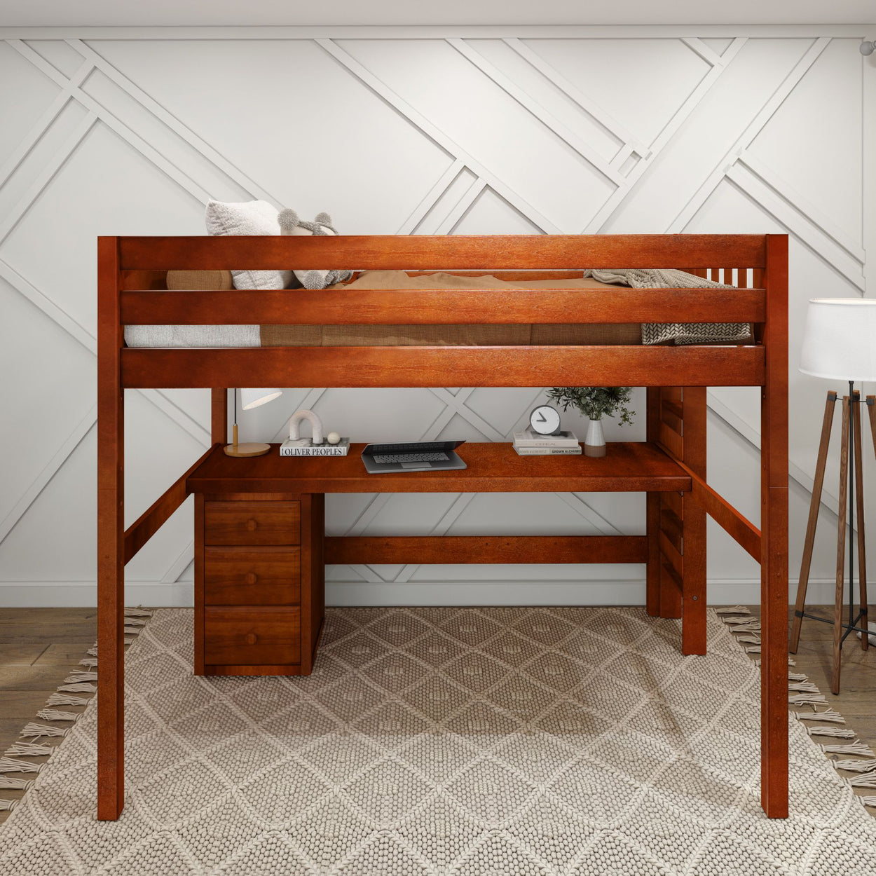 Wooden loft bed with integrated desk and storage drawers against a modern geometric wall design.