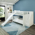 White wooden bunk bed with slide in modern kids' bedroom featuring a blue vertical accent wall, geometric blue rug, white dresser, wall art and large window with natural light