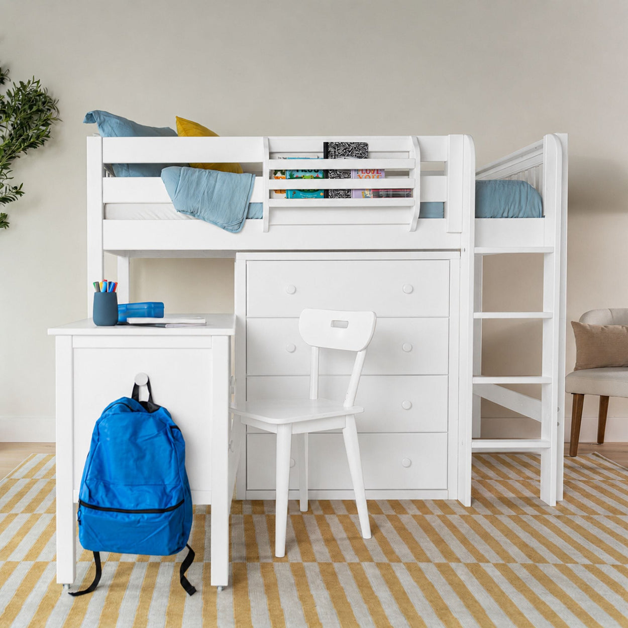 White loft bed with built-in desk and drawers in a kids' bedroom, blue bedding and backpack, bookshelf, neutral wall and yellow-striped rug