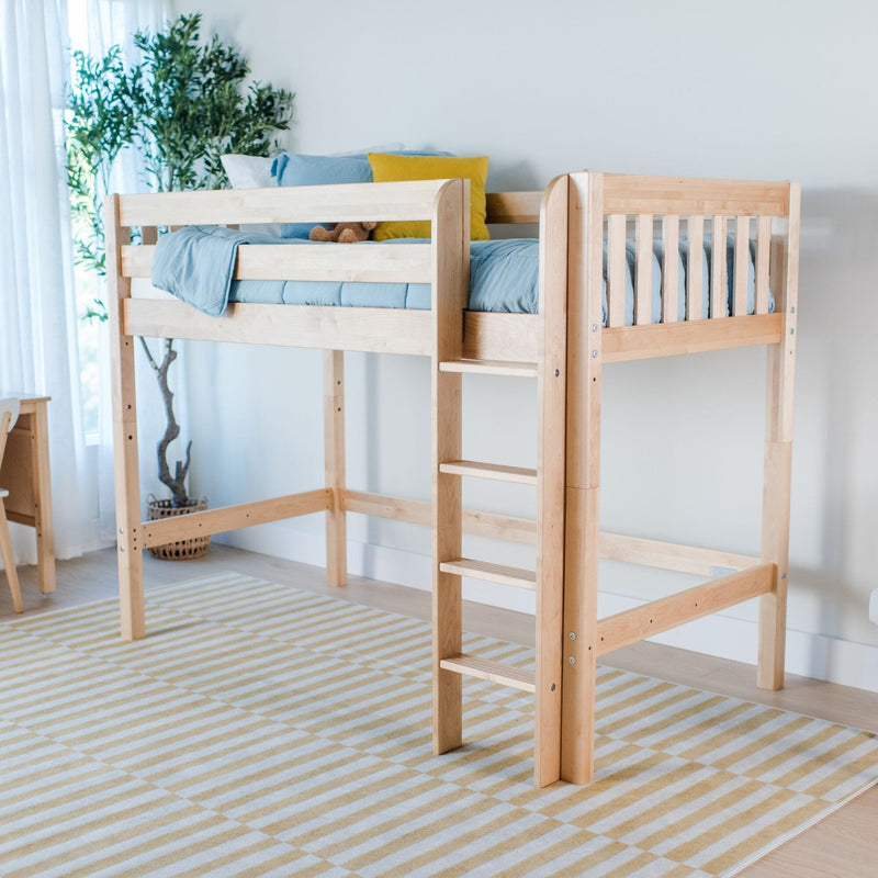 Natural wood loft bed with ladder in a bright kids' bedroom featuring blue bedding, a yellow accent pillow, striped rug, and potted plant