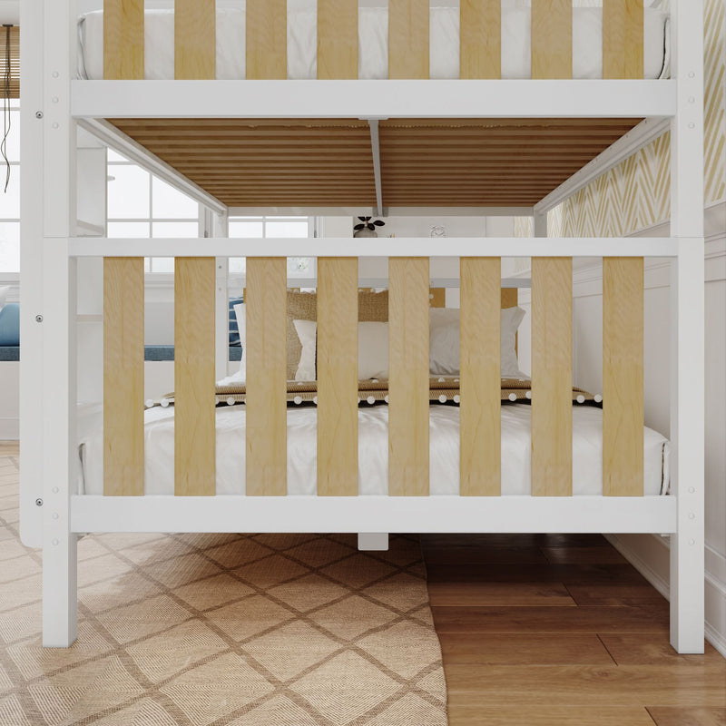 Modern white wooden bunk bed with natural wood slats in kids' bedroom, cozy pillows, patterned rug and hardwood floor