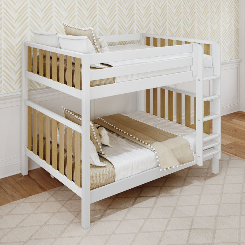 Modern white wooden bunk bed with natural wood slats and ladder, beige pom-pom pillows and neutral nursery decor against patterned wallpaper
