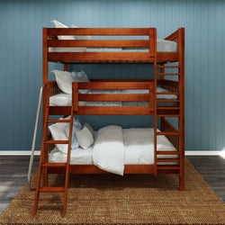 Three-tier solid wood bunk bed with ladder and safety rails in cherry finish against blue paneled wall, white bedding on woven rug — kids' bedroom furniture