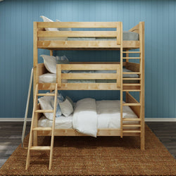 Natural wood triple bunk bed with ladders and white and blue bedding in a kids bedroom with blue paneled wall and woven rug