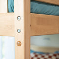 Close-up of natural wood bunk bed frame with metal bolts and wooden pegs, teal mattress and blurred bedding in background