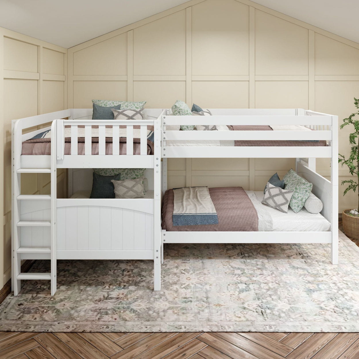 White twin-over-twin bunk beds with ladder, neutral quilts and patterned pillows against beige paneled wall in a cozy kids bedroom