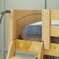 Close-up of solid pine wooden bunk bed ladder and safety guardrail with blue knit blanket and textured gray bedding