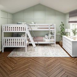 Modern white triple bunk bed with ladder in a spacious bedroom featuring light green paneled walls, cozy bedding, wooden herringbone floor, and a white dresser.