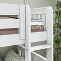 Close-up of a white wooden bunk bed ladder and safety rail with blue-and-white striped blanket, textured beige mattress and tassel throw in a styled kids’ bedroom with indoor plant