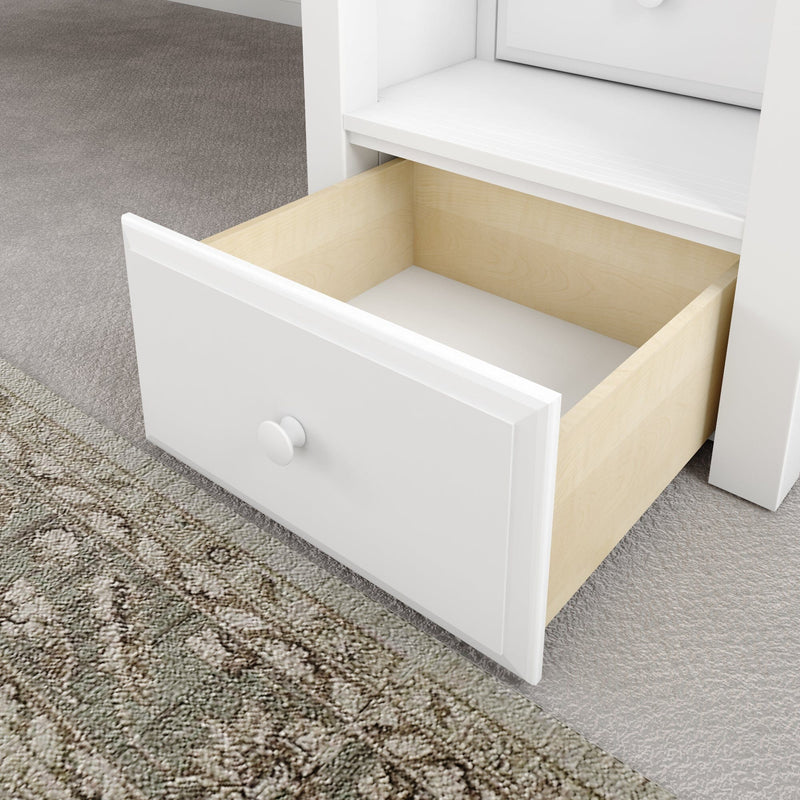 Open white dresser drawer with light wood interior and round knob on gray carpeted floor, modern bedroom storage solution