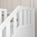 Close-up of a white wooden baby crib railing with slatted design and smooth painted finish against a beige paneled nursery wall