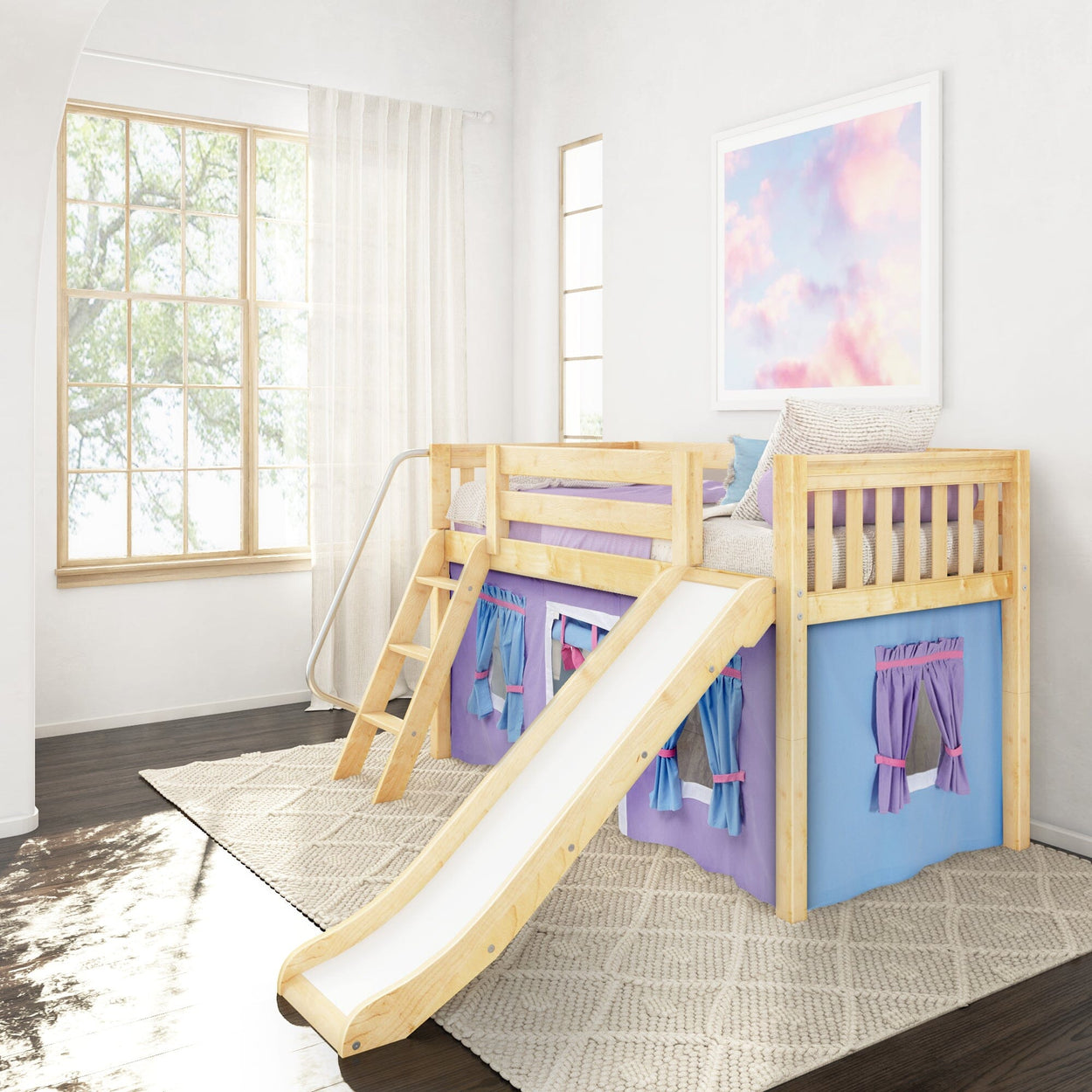 Wooden kids loft bed with slide and purple playhouse curtains in a bright white bedroom with large window, sheer curtains, pastel cloud wall art and textured cream area rug
