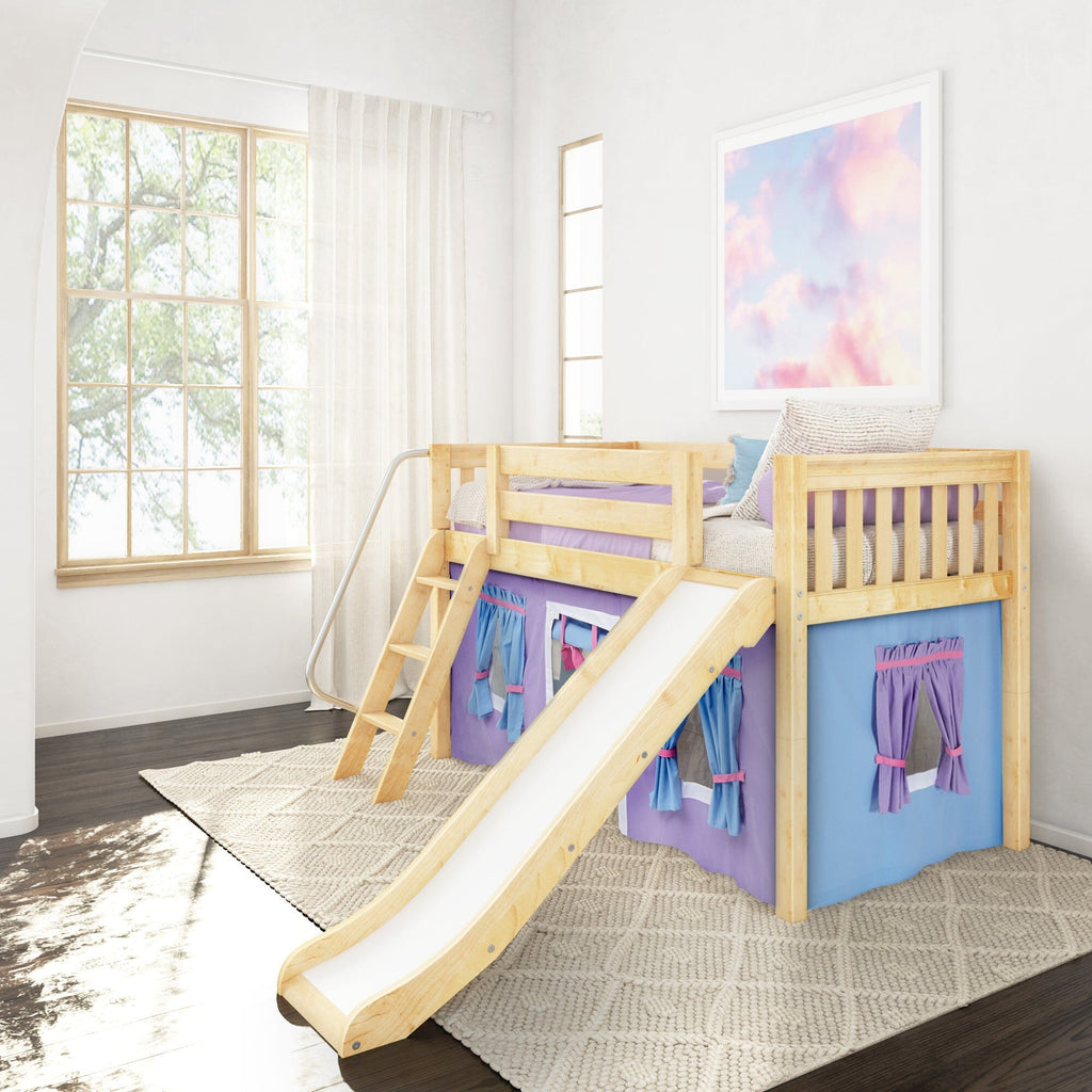 Children's wooden loft bed with slide and ladder — natural pine kids' bunk bed with purple and blue playhouse curtains in a bright bedroom with large window and pastel wall art