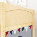 Close-up of light maple wood bunk bed headboard with red, white and blue triangular bunting in kids' bedroom nursery
