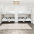 White bunk beds with built-in storage ladder in a bright coastal kids' bedroom with neutral bedding, blue accent pillows and rattan pendant light