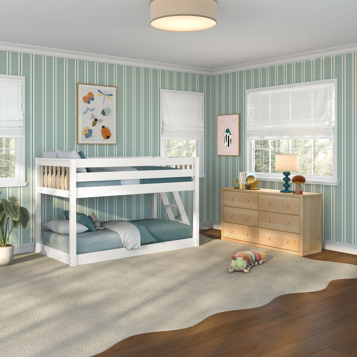 Children's bedroom with white twin-over-twin bunk bed, teal bedding, green striped wallpaper, light wood dresser, plush caterpillar toy on beige rug, sunlight streaming through windows