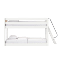 Modern white wooden bunk bed with metal ladder and safety rails, two-level bed with white bedding and pillows for kids, minimalist modern design