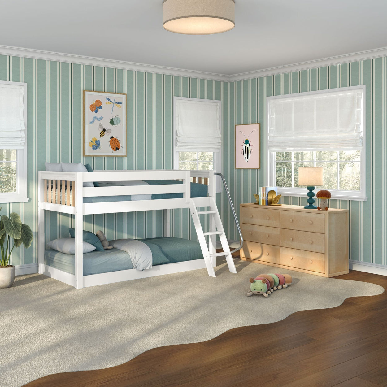 Kids bedroom with white bunk bed and ladder, green striped wallpaper, natural wood dresser, table lamp, wavy rug and plush caterpillar toy