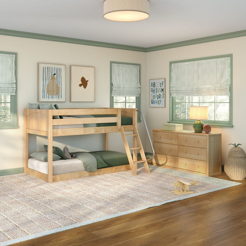 Children's bedroom with light wood bunk bed, green bedding and trim, striped roman shades, framed art and dresser in natural light.