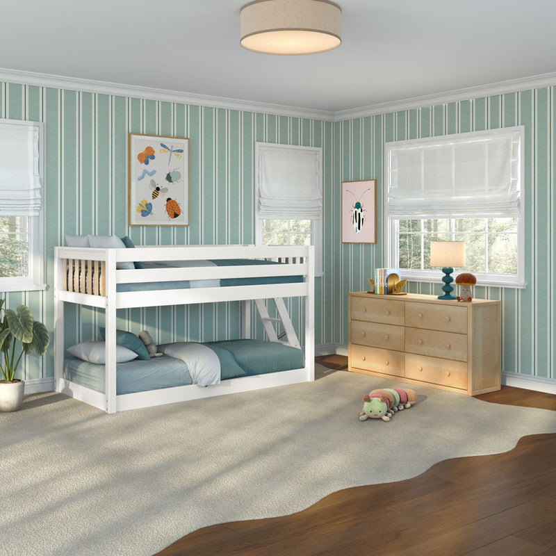 Children's bedroom with white bunk bed, teal striped wallpaper, wooden dresser, large windows with white roman shades, plush caterpillar on rug and framed insect art