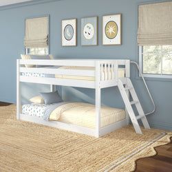 Modern white wooden twin-over-twin bunk bed with angled ladder in a coastal blue kids' bedroom, yellow-striped bedding, moon-and-star framed art, large windows, and natural jute area rug