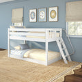 White wooden bunk bed in blue kids' bedroom with yellow striped bedding, patterned sheets, ladder, framed wall art, beige Roman shades and natural jute rug