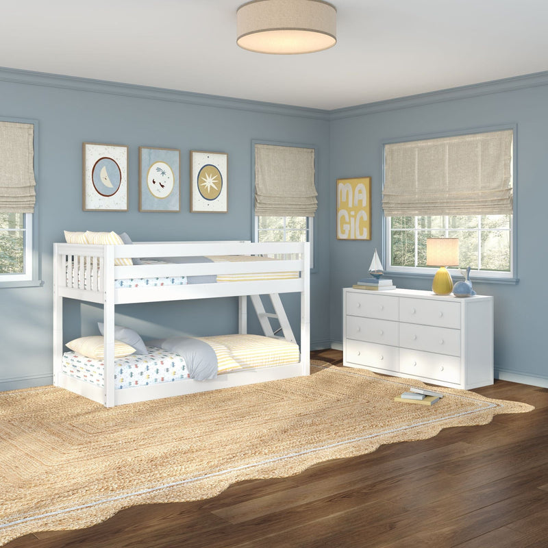 Children's blue bedroom with white bunk bed, white dresser, beige roman shades, woven jute rug and table lamp in natural light