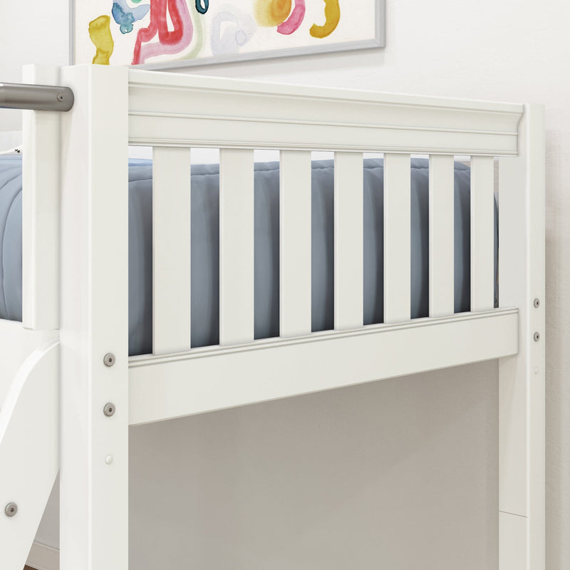 Close-up of white wooden crib rail with vertical slats, blue bedding and abstract nursery wall art