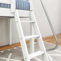 White wooden loft bed ladder with metal handrail and blue quilted mattress in modern kids' bedroom on hardwood floor
