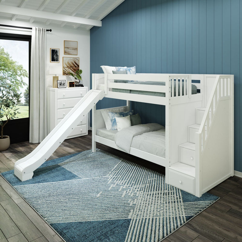 White loft bunk bed with slide and storage stairs in a modern kids' bedroom with blue vertical accent wall, white dresser, coastal artwork, potted plant and blue geometric rug