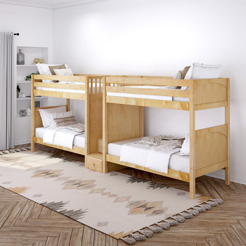 Natural wood bunk beds in bright neutral kids bedroom with white bedding, decorative pillows, patterned rug and built-in shelving