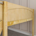 Close-up of light maple wood bunk bed frame with arched panel headboard and metal rail, natural finish against beige paneled wall
